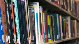 A shelf of books in the library, stacked so far they get blurry in the distance.